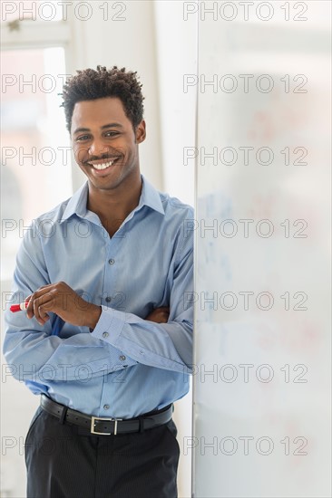 Businessman writing on whiteboard.