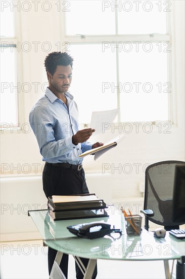 Businessman reading documents in office.