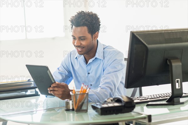 Businessman using tablet PC in office.