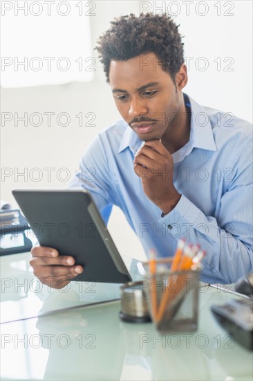 Businessman using tablet PC in office.