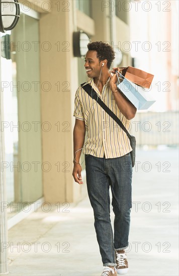 Man walking on street with shopping bags.