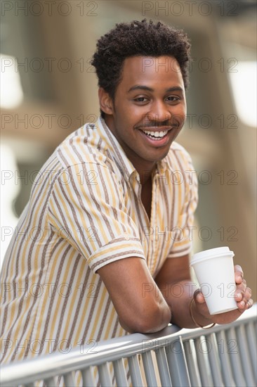 Man drinking coffee outdoors.