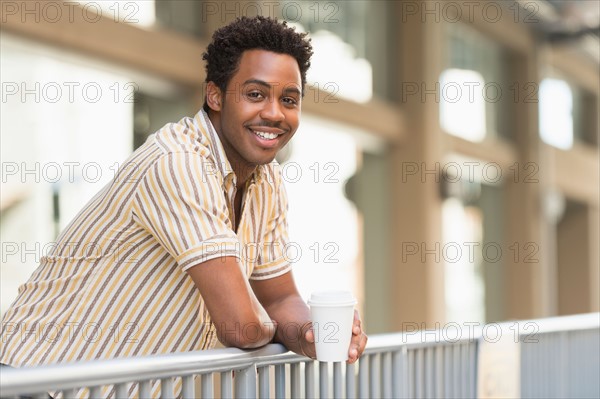 Man drinking coffee outdoors.