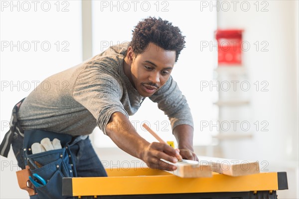 Carpenter measuring plank.