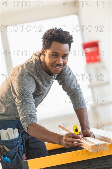 Carpenter measuring plank.