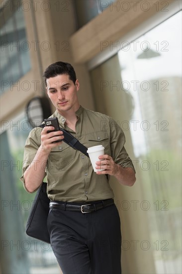 Man walking on street and text messaging.