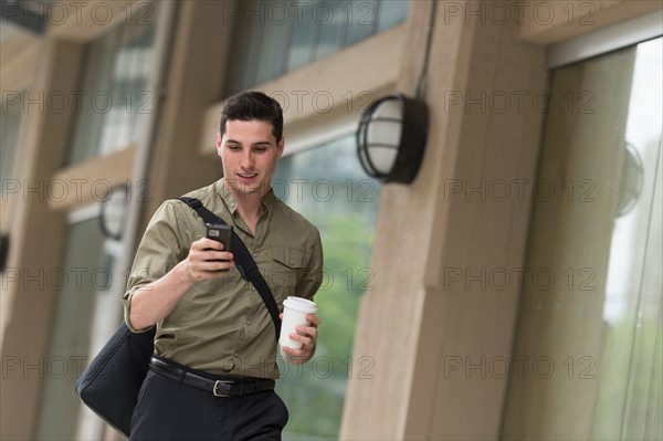 Man walking on street and text messaging.