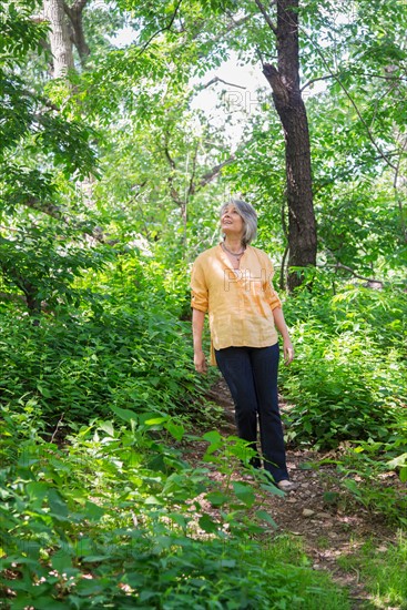 Central Park, New York City. Senior woman hiking in forest.