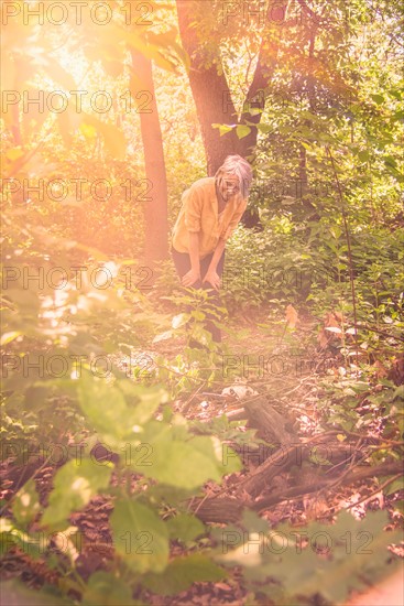 Central Park, New York City. Senior woman hiking in sunny forest.