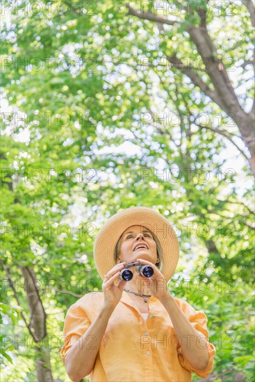 Central Park, New York City. Senior woman with binoculars in park.