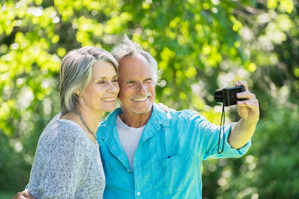 Central Park, New York City. Senior couple photographing themselves in park.