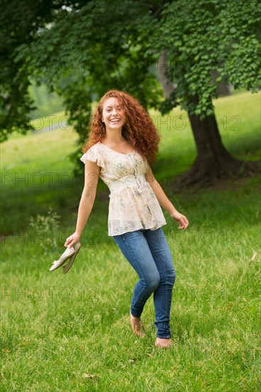 Young woman walking in park.