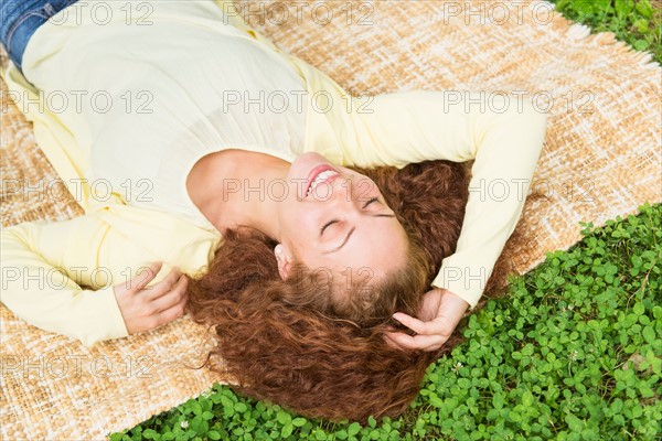 Woman lying on grass in park.