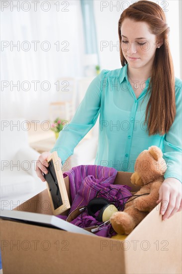 Teenage girl (14-15) with cardboard box