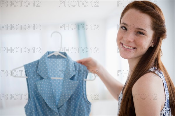 Teenage girl (14-15) holding dress