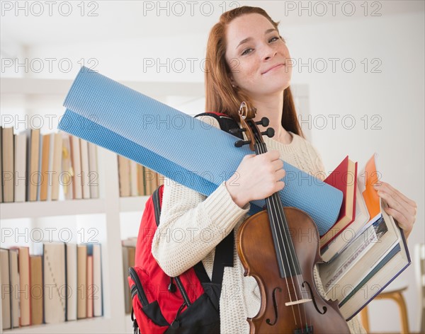 Teenage girl (14-15) carrying school equipment