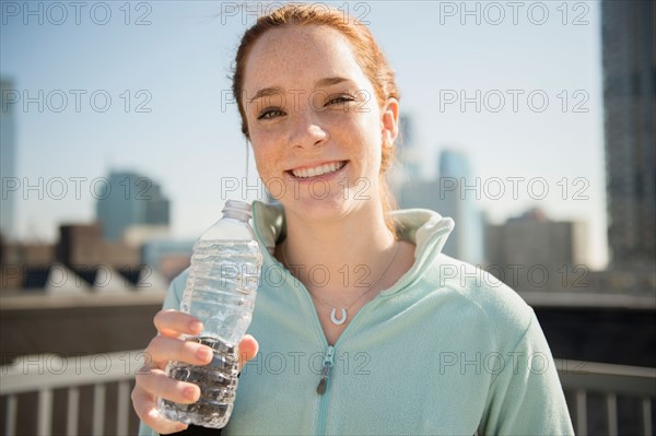 Teenage girl (14-15) with bottle of water