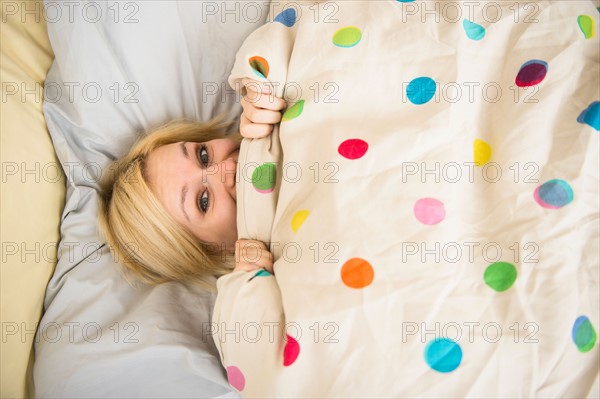 Young woman lying in bed