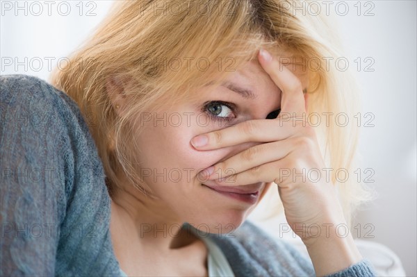 Young woman covering face