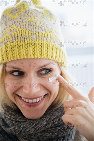 Portrait of smiling woman applying face cream