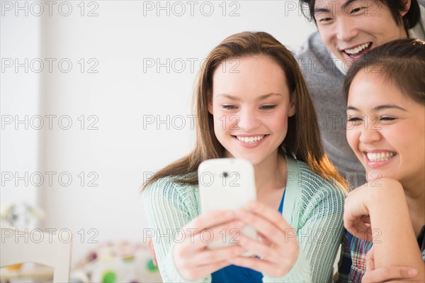 Young women and man using mobile phone