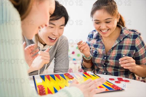 Young women and man playing backgammon