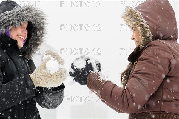 Two young women having snowball flight