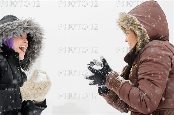 Two young women having snowball flight