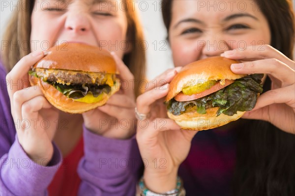 Young women eating hamburgers