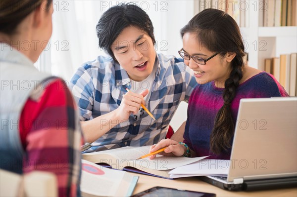 Young women and man studding in library