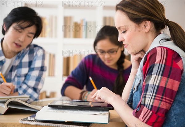 Young women and man studding in library