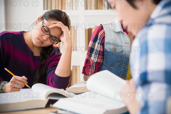 Young women and man studding in library