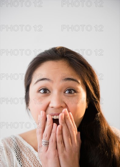 Studio shot of beautiful young woman laughing