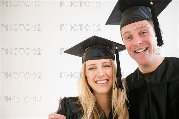 Couple of friends in graduation gowns