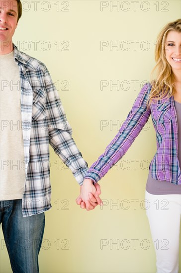 Studio shot of couple holding hands