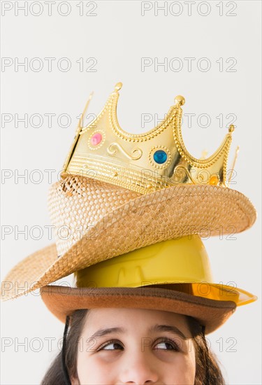 Girl (8-9) wearing stack of hats and crow on head