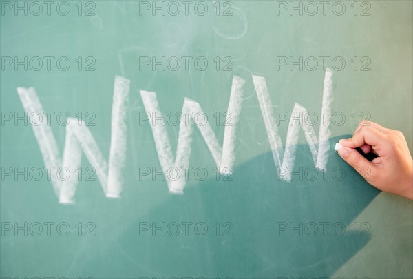 View of letters on blackboard and girl's hand