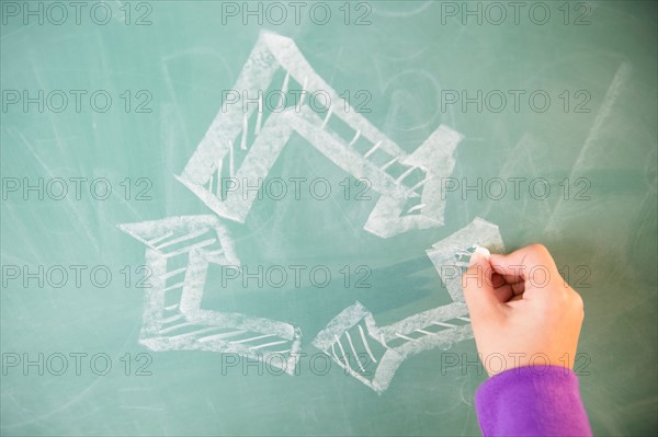 View of arrows on blackboard and girl's hand