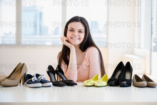 Young woman surrounded by shoes