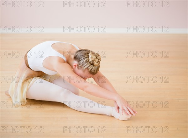 Portrait of teenage (16-17) ballet dancer bending over