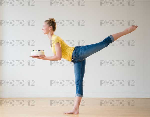 Portrait of teenage (16-17) ballerina holding cake