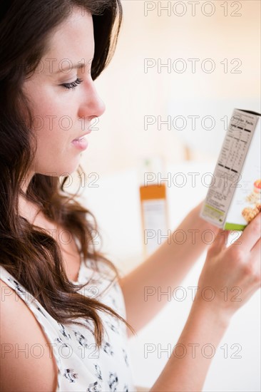 Woman checking nutrition label on box