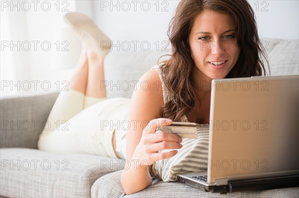 Young woman on sofa doing online shopping