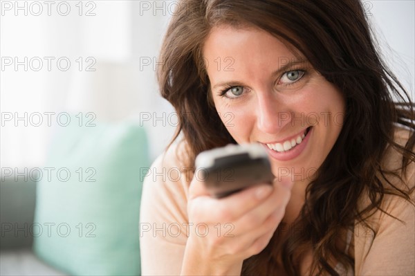 Young woman holding remote control