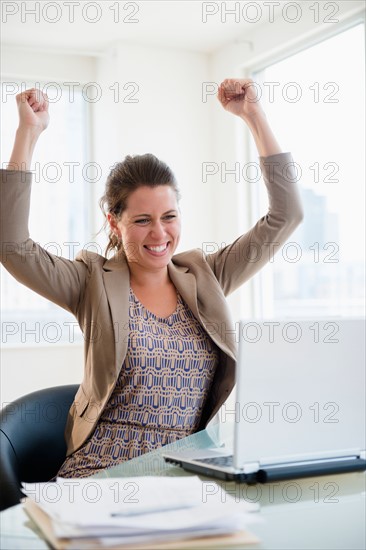 Portrait of cheering woman in office