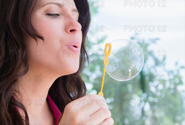 Portrait of woman blowing bubble