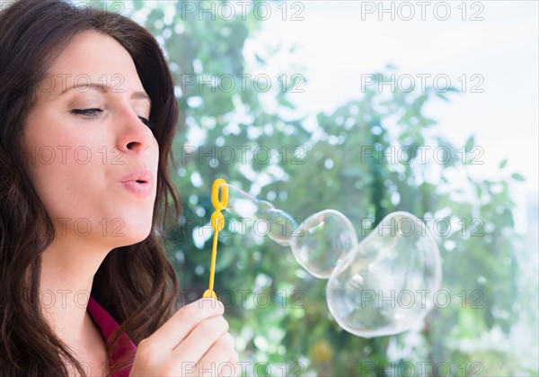 Portrait of woman blowing bubbles