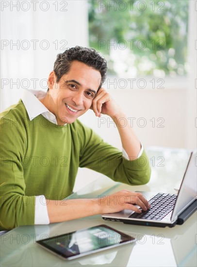 Portrait of man working on laptop at home