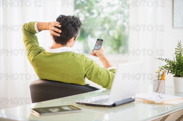 Rear view of man using mobile phone