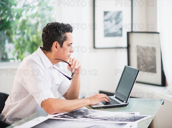 Portrait of man in his photography studio using laptop